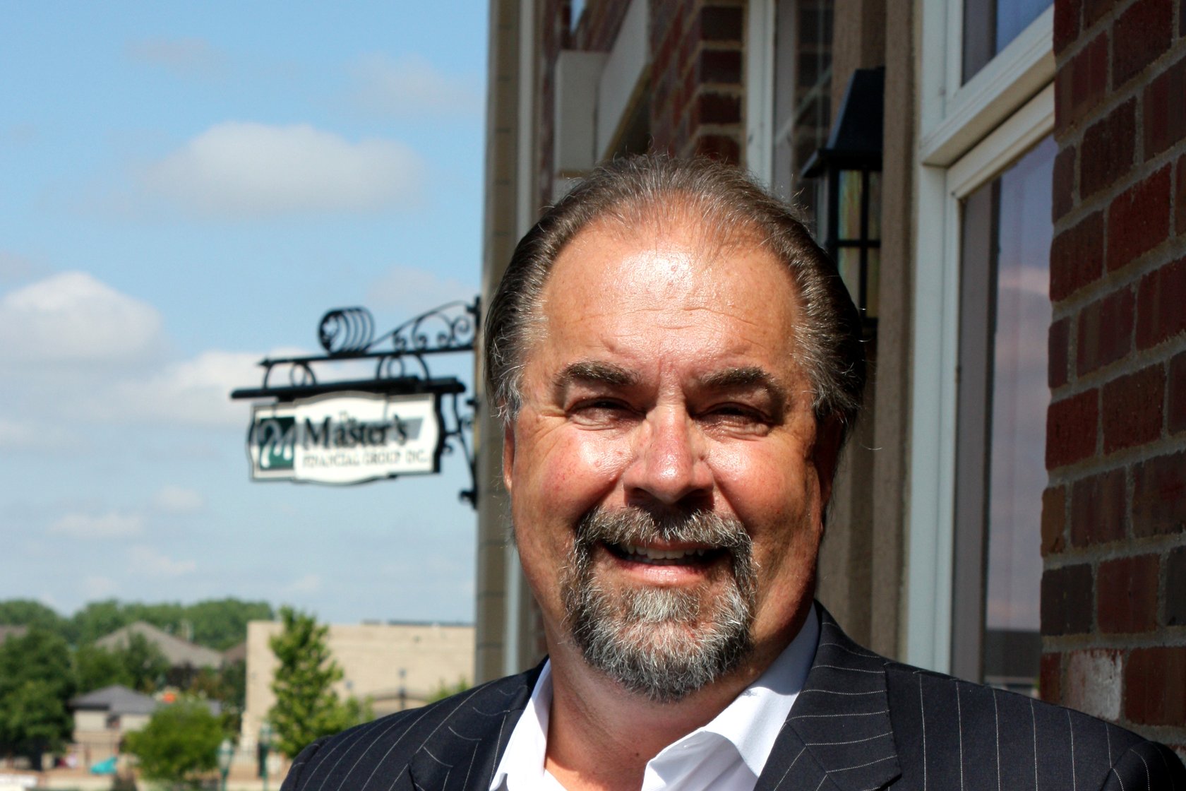 Charles L. Cooper outside his Greeley office, the firm's hanging sign beside him.