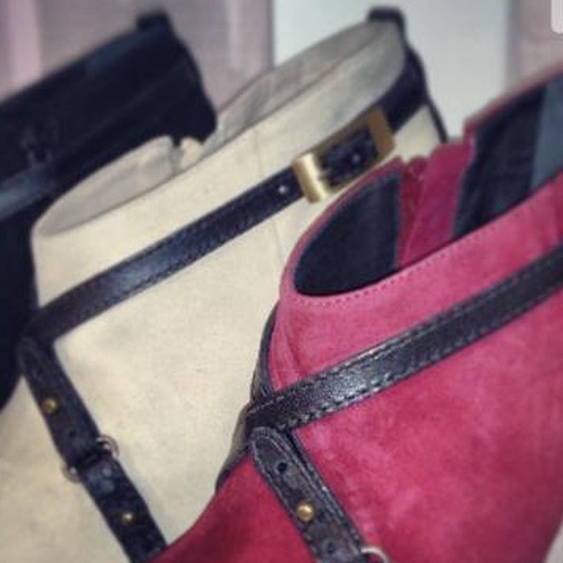 A pink suede bootie with leather straps and buckles