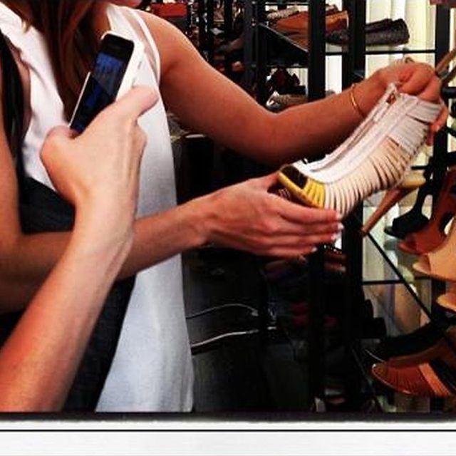 A buyer handling a fringed shoe in the showroom