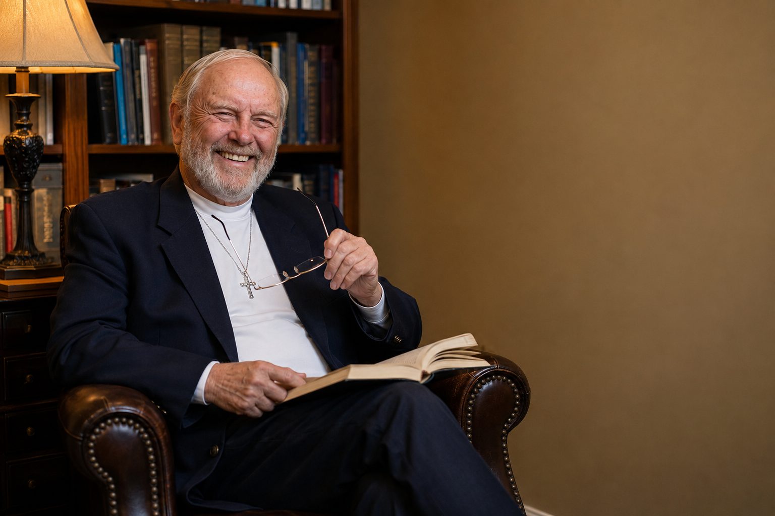 John W. Fisher seated in a book-lined study